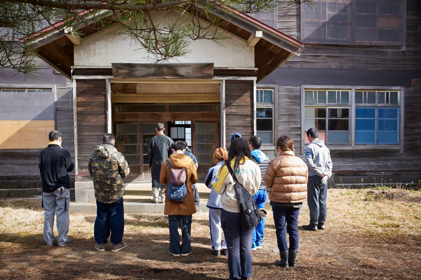 修繕前に小玉会館に手を合わせる実行委員の皆さま
